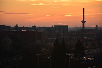 Fototapeta na wymiar Schweinfurt im Sonnenuntergang in Unterfranken Stadtansicht mit Industrie und Schornstein, Bayern, Deutschland
