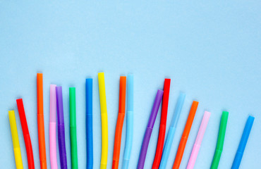 Colored plastic drinking straws on a blue background