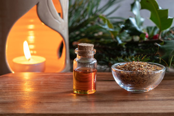 A bottle of essential oil with myrrh resin and a candle