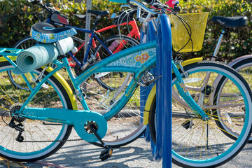Fototapeta na wymiar Colorful bikes parked on bike rack with yoga mat tied to the back