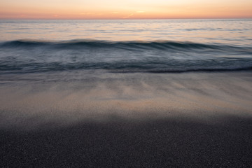 Long exposure of waves on beach at sunset
