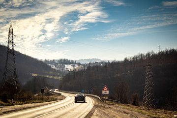 Asphalt mountain road at sunset with beautiful nature, stones and conifers. Mountain Tara in Serbia.