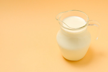 A jar with a milk on a beige background. Space for text or design.