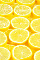A slices of fresh juicy yellow lemons.  Texture background, pattern.