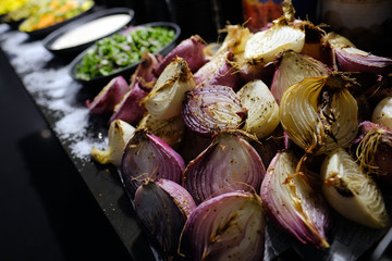 Close up onions cut in half and baked on a grill. Vegetarian food.