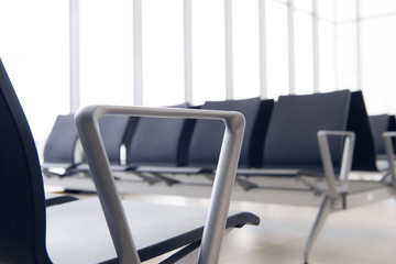 Empty airport terminal waiting area with chairs. Close up photo
