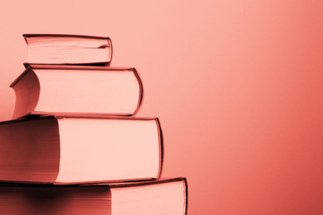 Education and reading concept. Pile of books - coral colored