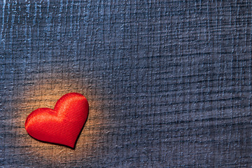 Red heart on a purple wooden surface