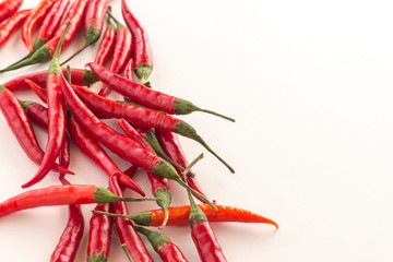 Red chili pods with green stems on white background. Top view.