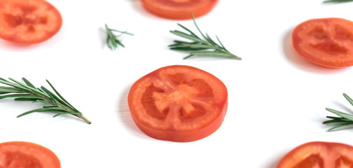 Slices of tomatoes on a white background. Frame for a banner with tomato and rosemary. White background with vegetables. View from above. Fresh tomatoes