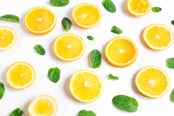 Fototapeta premium Fresh orange slices on a light background. Background with orange and mint. Beautiful photo with citrus. Vitamin C. Orange and Fresh Mint Pattern