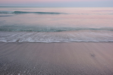 Beach waves washing ashore at sunrise