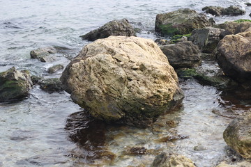 Large stone in the sea near the coast.	