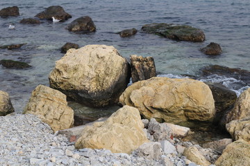 Fototapeta na wymiar Large stones lie near the shore in seawater.