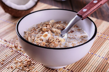 Healthy and tasty granola breakfast with coconut pieces and milk