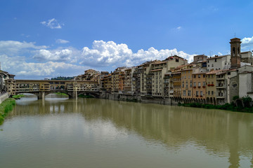 Obraz premium The Ponte Vecchio is a medieval stone closed-spandrel segmental arch bridge over the Arno River, in Florence, Italy, noted for still having shops built along it, as was once common.