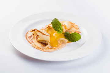 Two pancakes with honey on a white plate on a light background (close)