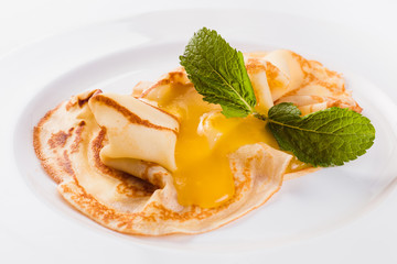 Two pancakes with honey on a white plate on a light background (close)
