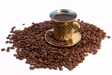 Golden Cup of coffee and roasted beans on white background
