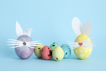 Decorated Easter eggs and cute bunny's ears on color background