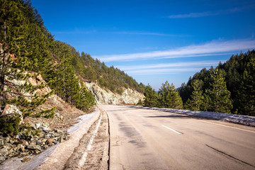 Asphalt mountain road at sunset with beautiful nature and dangerous and unstable stones and rocks near the road. Tara mountain in Serbia.