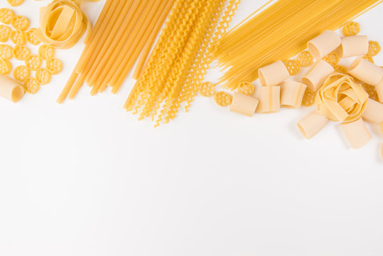 An Overhead Photo Of Different Types Of Pasta, Including Spaghetti, Penne, Fusilli, And Others, Flay Lay On A White Background With A Place For Text