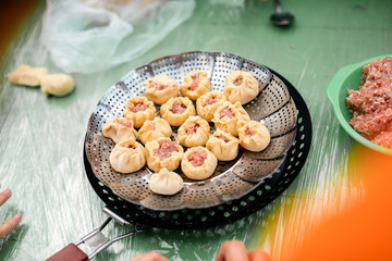 Colorful mandalLittle raw meat dumplings in the pan cooking on the fire a made from bright ropes