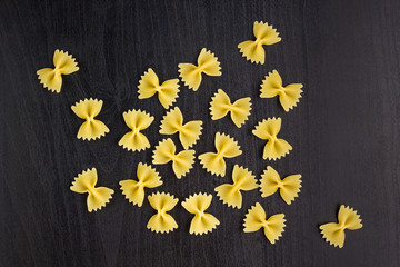 A pile of farfalle pasta on black background