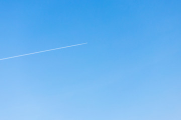 on the background of blue sky white trail from the aircraft.