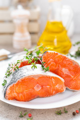 Fresh raw salmon fish steaks on white kitchen background