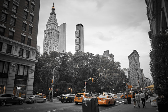 New York city buildings in balck and white, with only yellow color showing on cabs