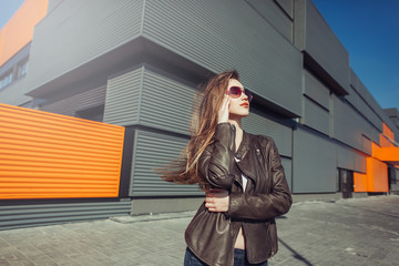 Positive young beauty girl with long hair near shopping center in fashionable sun glasses. Beauty, fashion, shopping concept