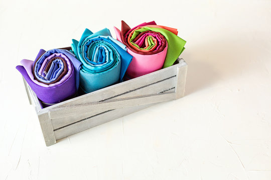 Rolled up colorful fabric swatches on white background