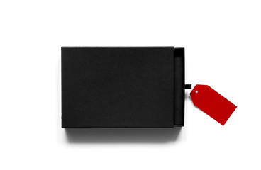 Fototapeta premium Flatlay of black cardboard box with red label on white background.