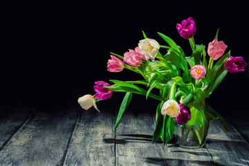 Beautiful bouquet of of colorful tulips on dark background. Spring flowers for Mother's Day, International Women's Day, birthday