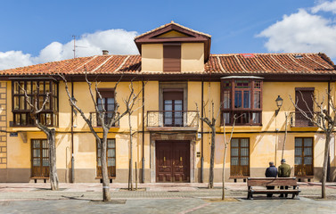 Two older men leaning against a bench in Leon, Spain