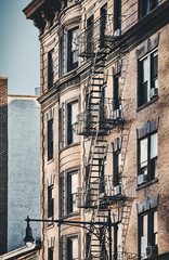 New York old building with fire escapes, color toned picture, USA.