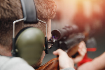 Man directs firearm gun pistol at target firing range or shooting range
