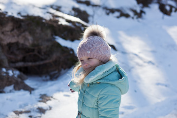 baby girl playing in snowy winter forest