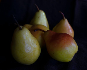 Fototapeta na wymiar Five ripe pears on a black background