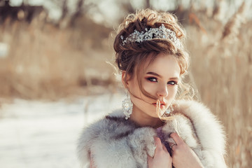 Luxury portrait of beautiful caucasian bride in wedding fashionable dres and crown and jewelery with diamonds. Winter, wedding, lixury concept