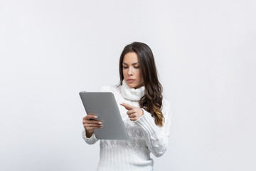 beautiful young woman in a studio with a tablet showing something