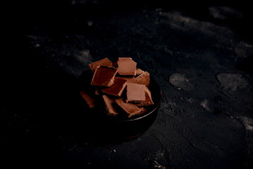 Fototapeta na wymiar chocolate pieces on black background