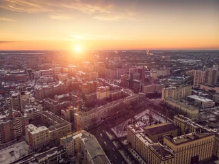 Poster Aerial view of winter midtown of Voronezh city with buildings, roads and skyline at sunset © DedMityay
