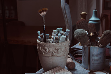 Artistic equipment. Paint brushes on a table in a workshop.