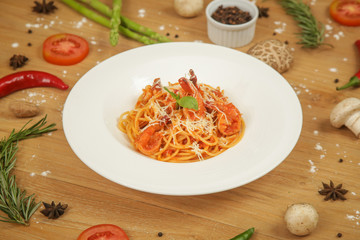 A portion of creamy seafood pasta surrounded with a variety of herbs and spices