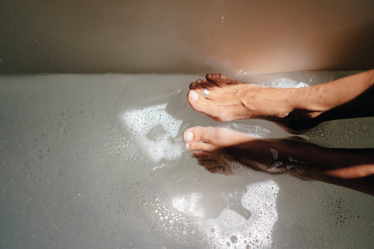 Woman taking footbath, partial view