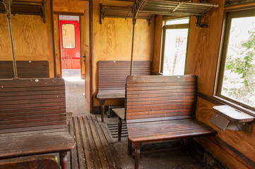 Fototapeta na wymiar Blick in ein altes Zugabteil mit Holzsitzen und Ablagen