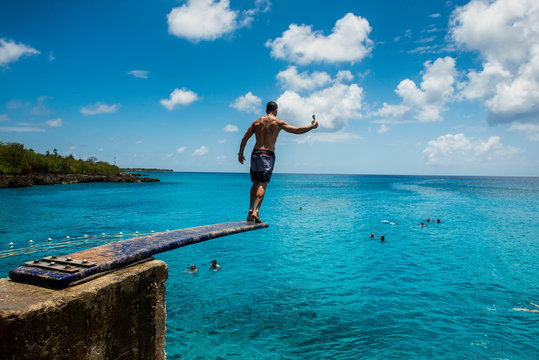 Caribbean, Colombia, San Andres, man on diving board above turquoise water