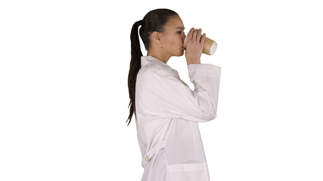 Female Doctor Drinking Coffee And Walking On White Background.